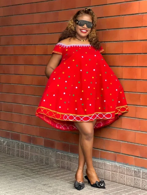 Cameroon women’s red off‑shoulder dress with multicolored embroidery and polka dots – African cultural attire